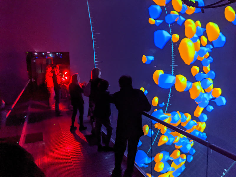 Researchers on the bridge immersed in a colorful in-sphere data visualization